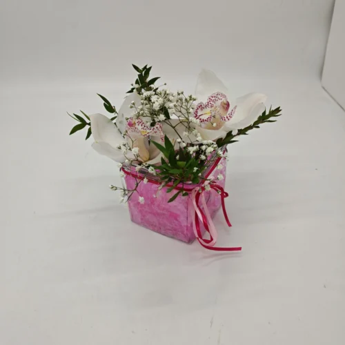 Ανθοσύνθεση με ροζ τζελ σε γύαλινο κύβο με ορχιδέες συμπίντιουμ (Cymbidium)